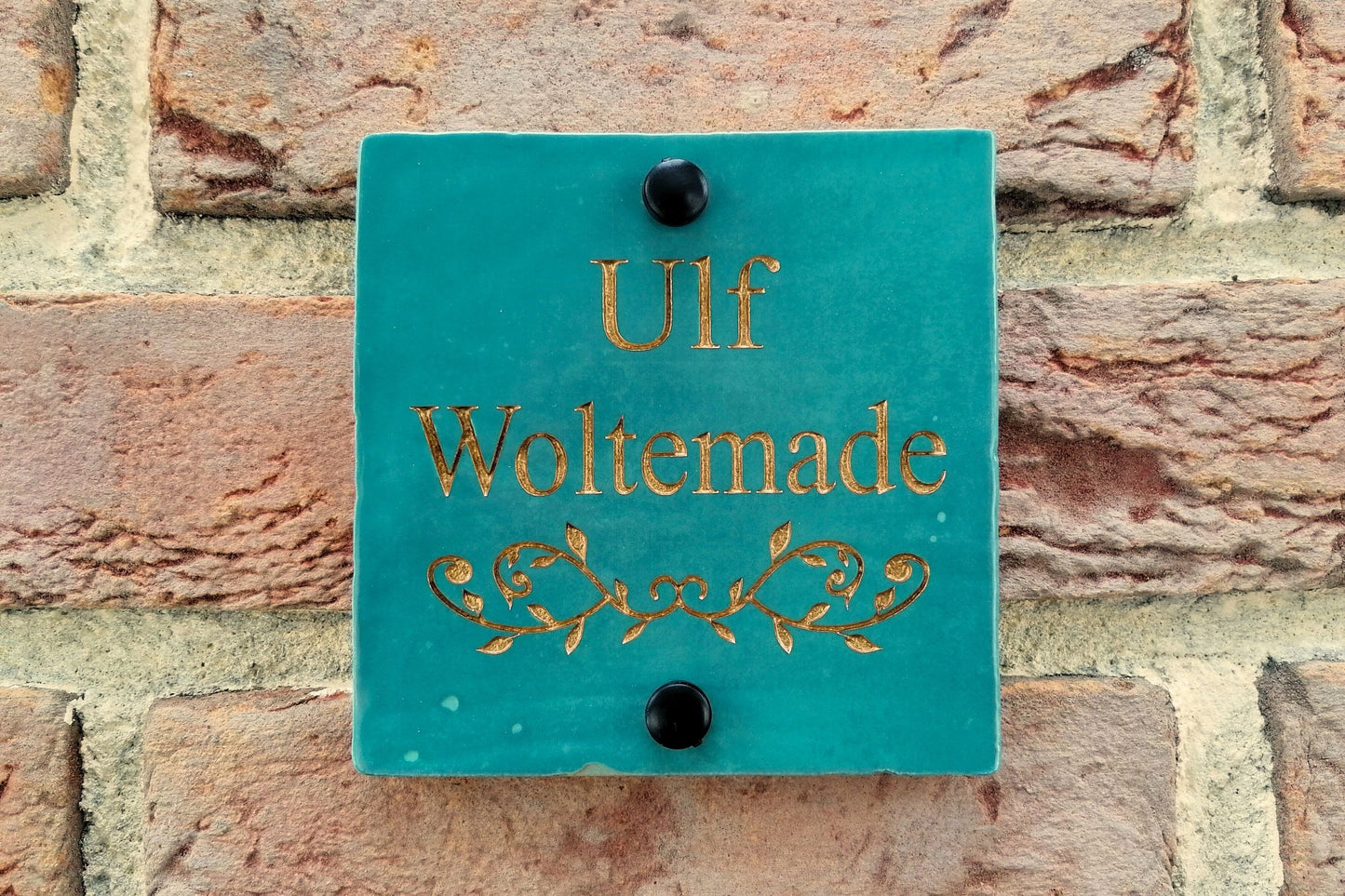 Turquoise ceramic tile address sign engraved with house name and decorative floral motif underneath. Engraving paint options include gold, copper, silver and black.