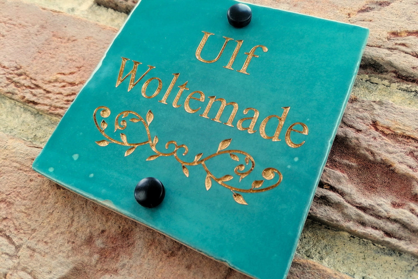 Turquoise ceramic tile address sign engraved with house name and decorative floral motif underneath. Engraving paint options include gold, copper, silver and black.