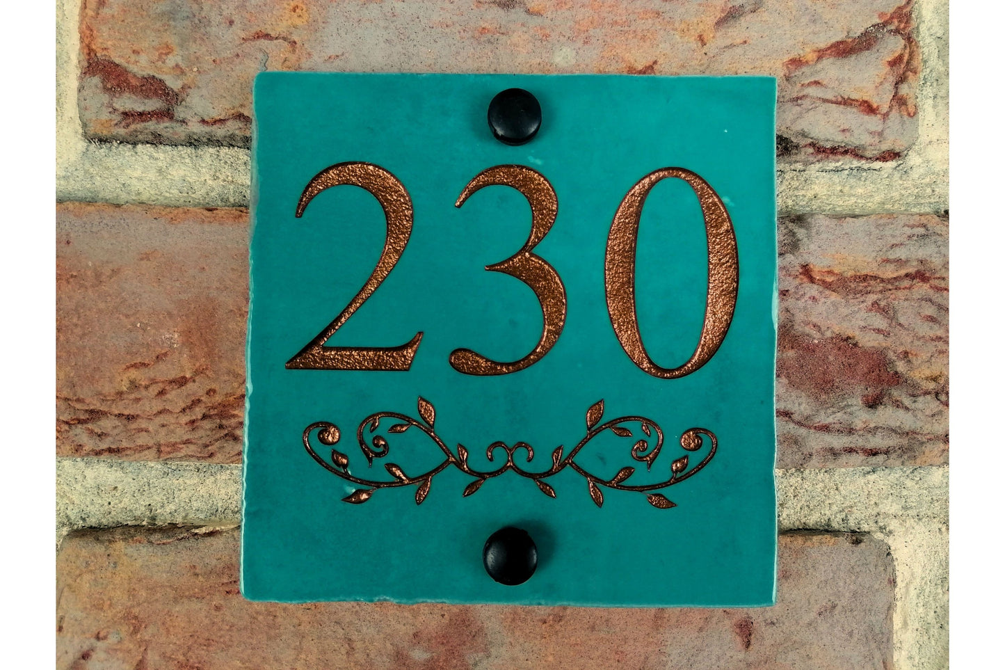 Turquoise ceramic tile address sign engraved with house name and decorative floral motif underneath. Engraving paint options include gold, copper, silver and black.