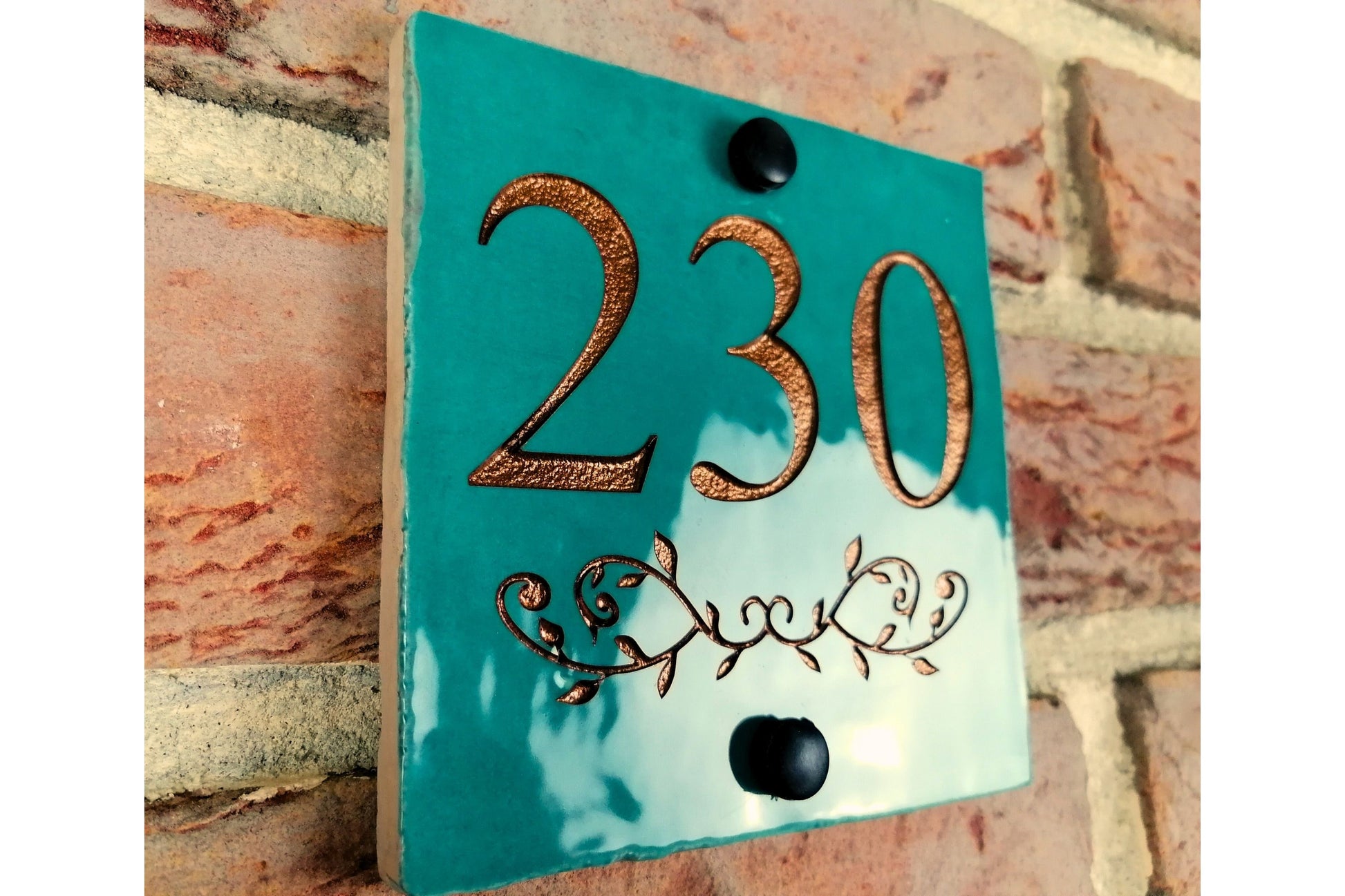 Turquoise ceramic tile address sign engraved with house name and decorative floral motif underneath. Engraving paint options include gold, copper, silver and black. 